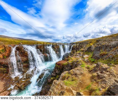 Charming View Of  Kolufossar Waterfall At Summer Sunny Day.  Popular Tourist Travel Destination In I