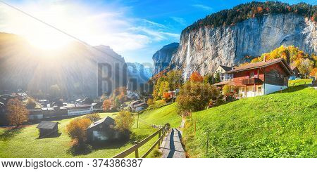 Gorgeous Autumn Landscape Of  Alpine Village Lauterbrunnen With Famous Church And Staubbach Waterfal