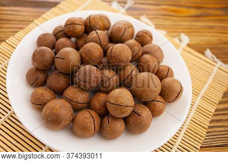 Delicious Macadamia Nuts On A Plate On A Wooden Background