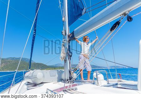 Little Boy On Board Of Sailing Yacht On Summer Cruise. Travel Adventure, Yachting With Child On Fami