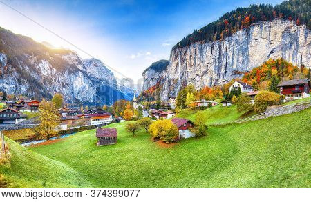 Amazing Autumn Landscape Of Touristic Alpine Village Lauterbrunnen With Famous Church And Staubbach 