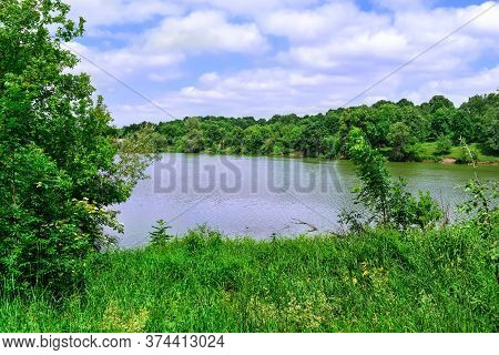 A Pond Among Spring-summer Greenery In The Uhroidy Village Of Sumy Region (ukraine, Europe). Meadow 