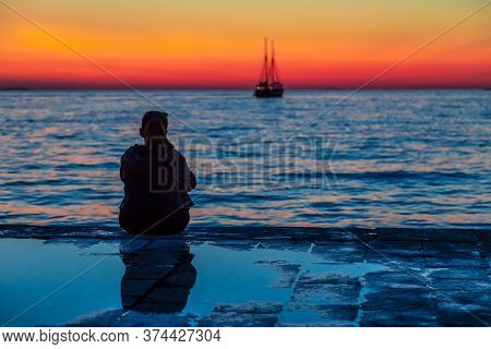 Silhouette Of A Young Woman Looking Out To Sea At Sunset. Adriatic Sea At Zadar Town, Croatia, Europ
