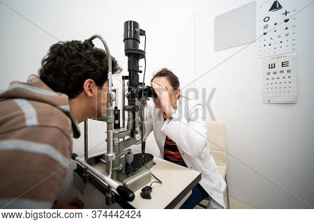 A teenage boy checking his eyes at an ophthamology center