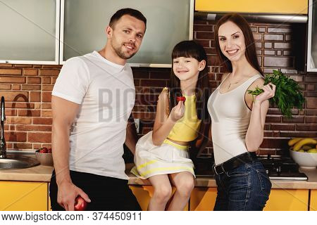 Healthy Food Advertising. Attractive Young Family, Mam, Dud And Little Daughter Posing In A Trendy K