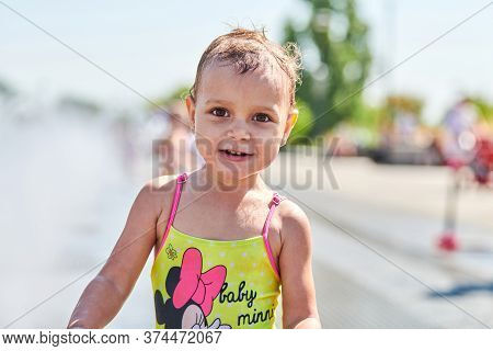 Voronezh, Russia - 24.08.2019 - Cute Baby Playing In Fountain. Little Girl Playing With Waterspouts.