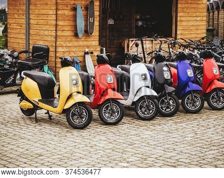 Russia, Sochi 14.03.2020. Many Multicolored Electric Motorcycles Stand In A Row On Paving Stones Aga