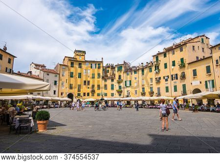 Lucca, Italy - August 14, 2019: Tourists And Locals Visit Ancient Amphitheater Square Or Piazza Dell