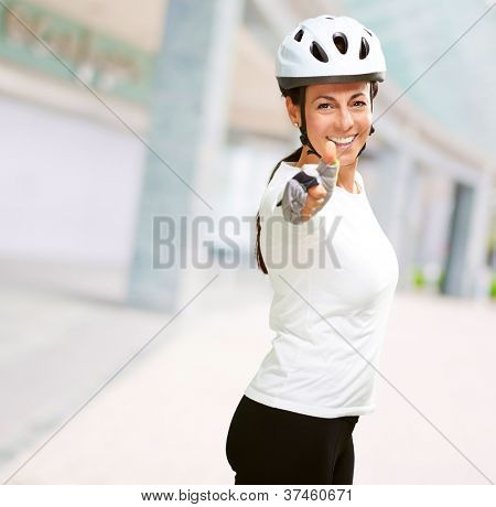 Femme portant casque montrant le pouce vers le haut, en plein air