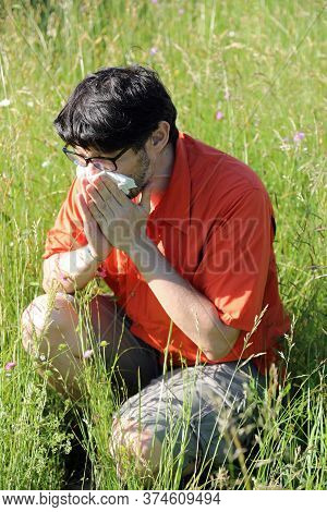Allergic Boy Blows His Nose In The Middle Of The Meadow In Spring
