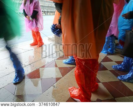 People With Plastic Gaiters In Venice During High Tide