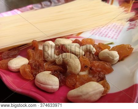 Closeup Shot Of Cashew Nuts And Dry Grapes Taken In A Plate With Long Strands Of Semiya For Payasam 