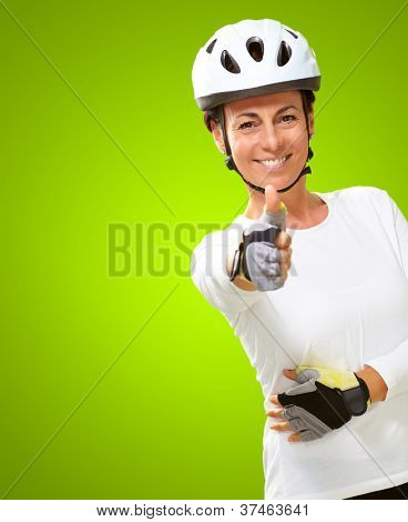 Femme portant casque montrant le pouce en haut isolé sur fond vert