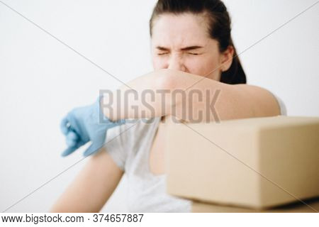 The Girl Pushes Her Elbow In Gloves At The Table With Corton Boxes In The Foreground. Free Space For