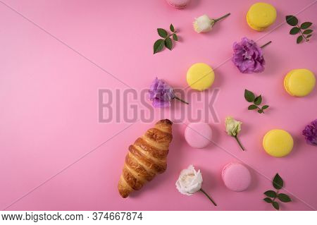 French Pastry - Macarons And Croissant With Flowers On Pink Background With Copy Space. Top View