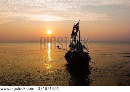 Silhouette Of Two People On A Fishing Boat That Is About To Go Fishing In The Morning Sun.copy Space