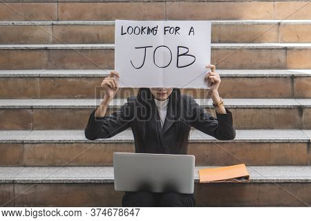 Asian Business Woman Trying To Find Job And Showing Paper Sign To Tell Other People That Her Looking