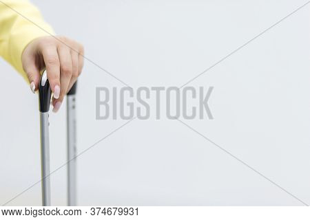 Cropped Shot Of Female Hand Carrying A Suitcase Over White Background With Copyspace.