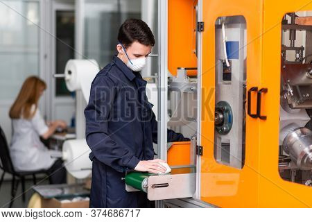 A Man Works At A Machine For The Manufacture Of Medical Masks With Nanofiber. Coronovirus And Covid-