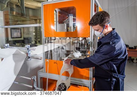 A Man Works At A Machine For The Manufacture Of Medical Masks With Nanofiber. Coronovirus And Covid-