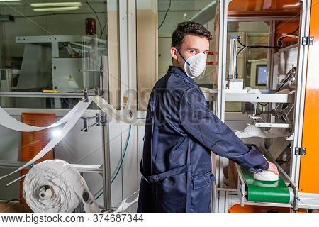 A Man Works At A Machine For The Manufacture Of Medical Masks With Nanofiber. Coronovirus And Covid-