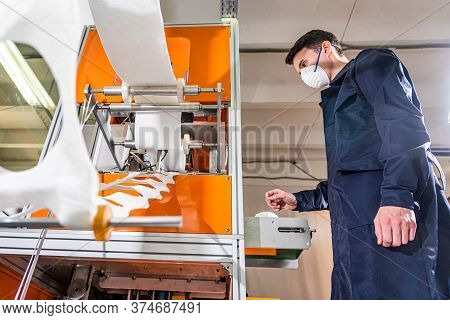 A Man Works At A Machine For The Manufacture Of Medical Masks With Nanofiber. Coronovirus And Covid-