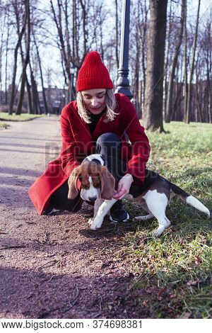 Pretty Young Girl In Redd Coat Playing With Dog Outside In Green Park, Lifestyle People Concept