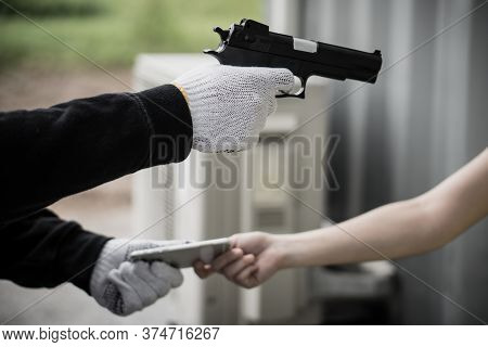 Dangerous In The City. Robber Pointing Gun To Victim In The Car And Try To Rob Mobile Phone From Her