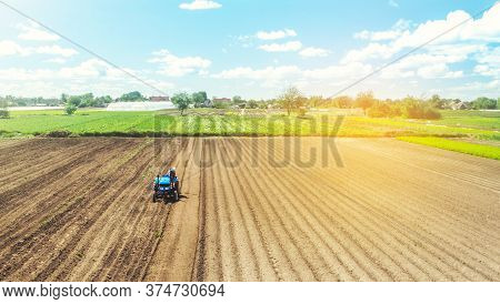Farmer On Tractor Loosens And Grinds The Soil. Preparing The Land For A New Crop Planting. Farming A