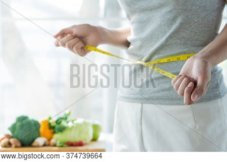 Eat Good Food For Good Shape Concepts. Woman Measuring Her Body By Measure Tape Have A Vegetables On