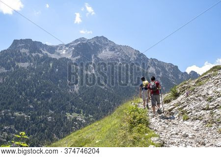 Two Boys Doing Trekking Reaching The Top Of The Mountain In Spanish Pyrenees