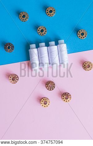 Row Of Whitethread Spools And Small Bobbins Of Thread Used In A Sewing Machine