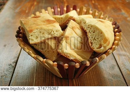 Pile Of Cut Shoti Or Georgian Bread In A Basket Isolated On Wooden Table