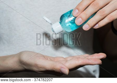 Antispetic Sanitizer In Hands. Girl Treats Her Hands With Antibacterial Agent.