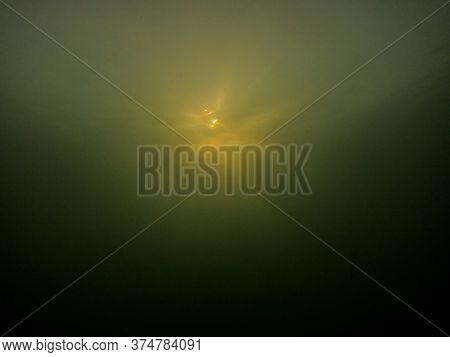 View Of The Sun From The Bottom Of A Lake In The Summer When Diving