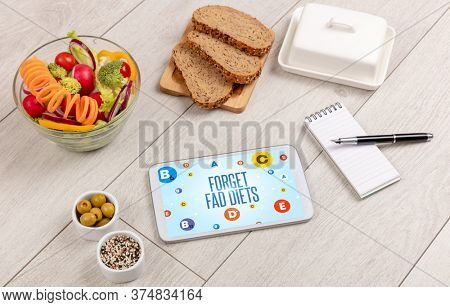 Healthy Tablet Pc compostion with FORGET FAD DIETS inscription, weight loss concept