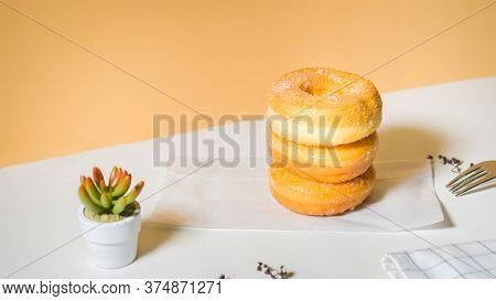 Homemade Deep Fried Donuts In Stack With Sugar Standing On Crumpled Paper With White Table.
