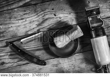 Razor, Shaving Brush And Barber Clipper On A Wooden Background. Black And White Photo. Close-up. Bar