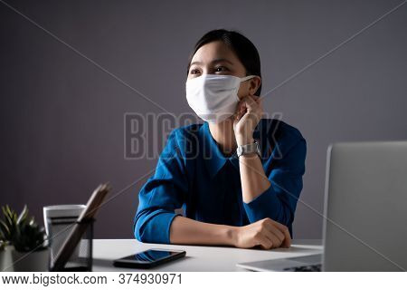 Asian Woman Wearing Protective Face Mask Working On A Laptop At Office. Wfh. Work From Home. Prevent