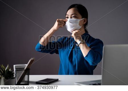 Asian Woman Wearing Protective Face Mask Working On A Laptop At Office. Wfh. Work From Home. Prevent