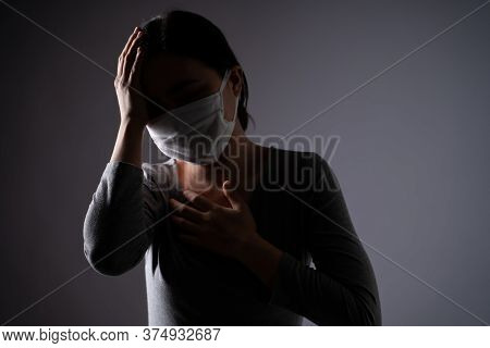 Asian Woman Wearing Protective Face Mask Was Sick With Headache Touching Her Head And Standing Isola