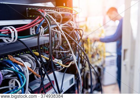 Network Engineer Working In Server Room. Connecting Network Cables To Switches