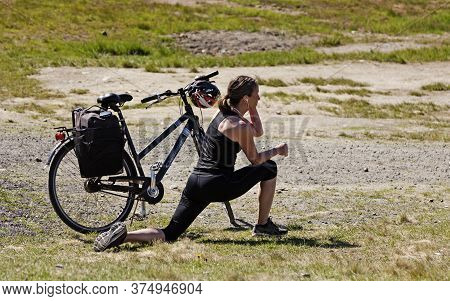 Umea, Norrland Sweden - June 8, 2020: Woman Stretches After Finishing Bicycle Training