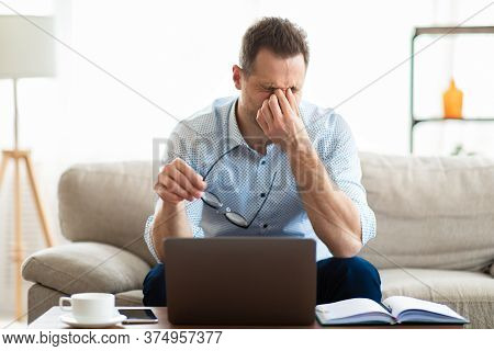 Fatigue From Work. Tired Man Feeling Eyestrain, Holding Glasses, Rubbing Dry Irritated Eyes, Massagi
