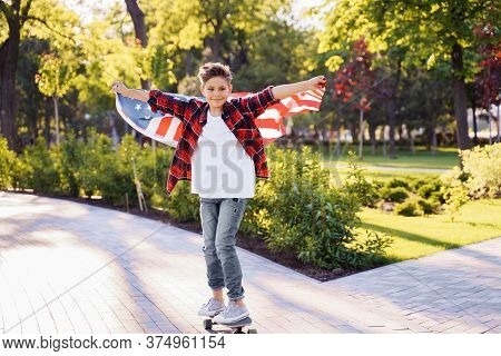 U.s. Independence Day. A Young Guy American Or Caucasian, 8 Years Old Riding At The Speed On A Skate