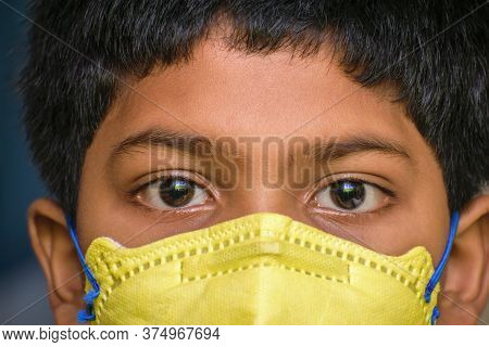 Isolated Young Indian Boy With Prominent Eyes Wearing N95 Face Mask For Protection Against Covid 19