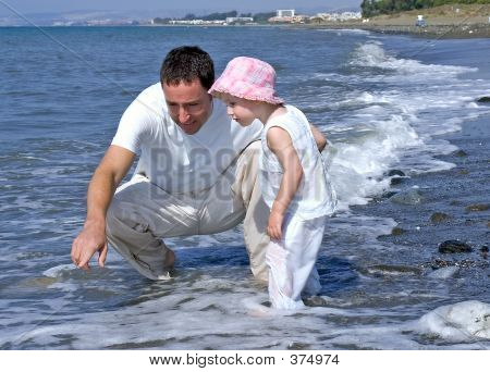 Far och dotter spelar i havet