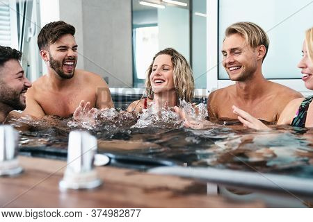 Happy Friends Enjoying Vacations In Jacuzzi Luxury House - Young People Having Fun Together In Hot T