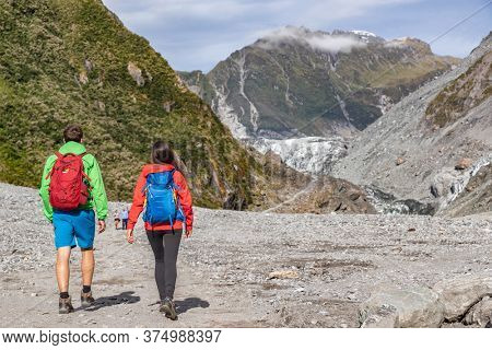 New Zealand tourists backpacking in nature landscape by Franz Josef Glacier, Westland Tai Poutini National Park, South Island, New Zealand. Couple on travel arriving at famous viewpoint.