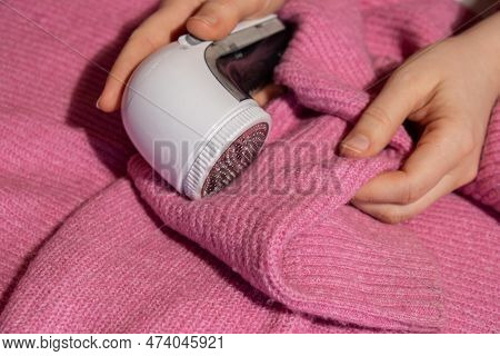 Woman Using Anti-pilling Razor At Home. Device For Shaving Clothes. Anti-plush Fabric Shaver. Electr